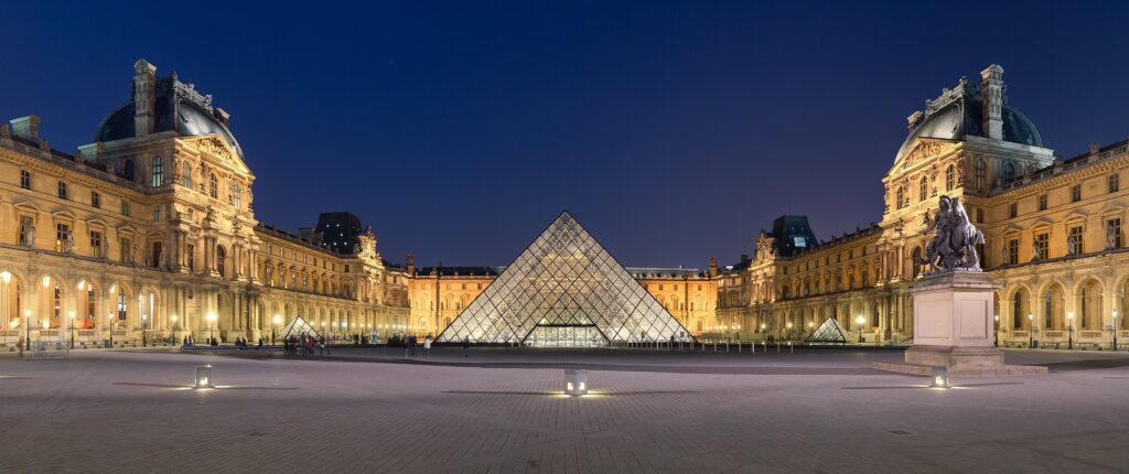 Napoleon courtyard of the Louvre museum at night time, with Ieoh Ming Pei's pyramid in the middle.
